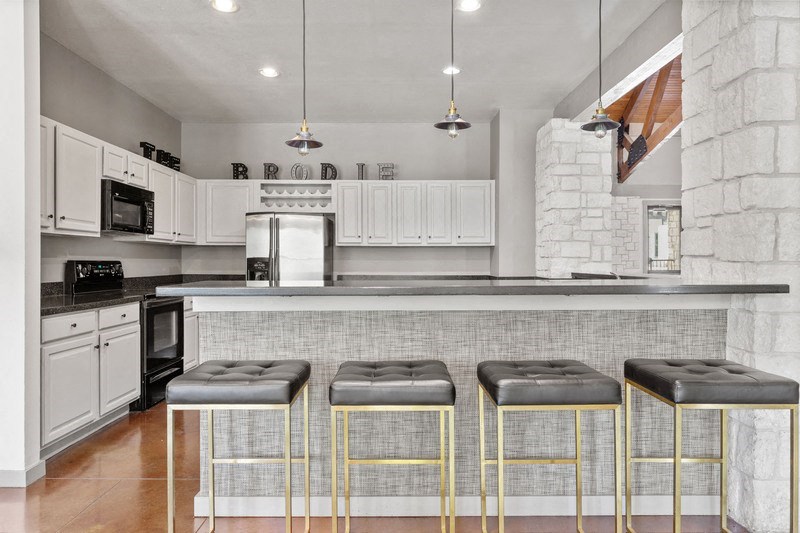 a kitchen with a counter top and three stools