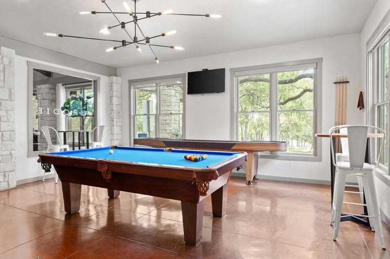 a game room with a pool table and a flat screen tv