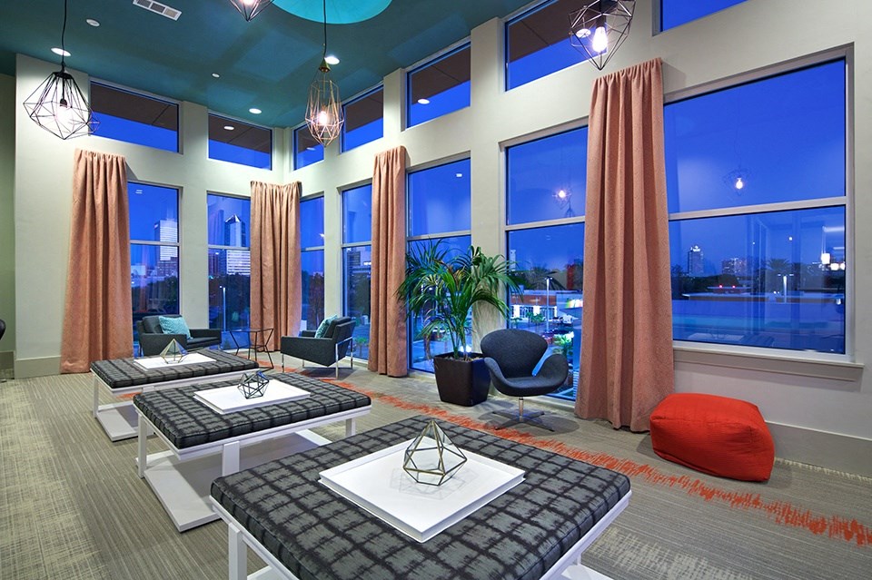 A room with a table and chairs with a view of the city.