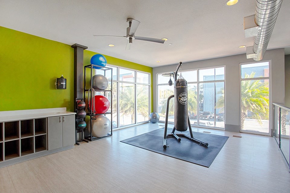 A room with a green wall and a black mat on the floor.