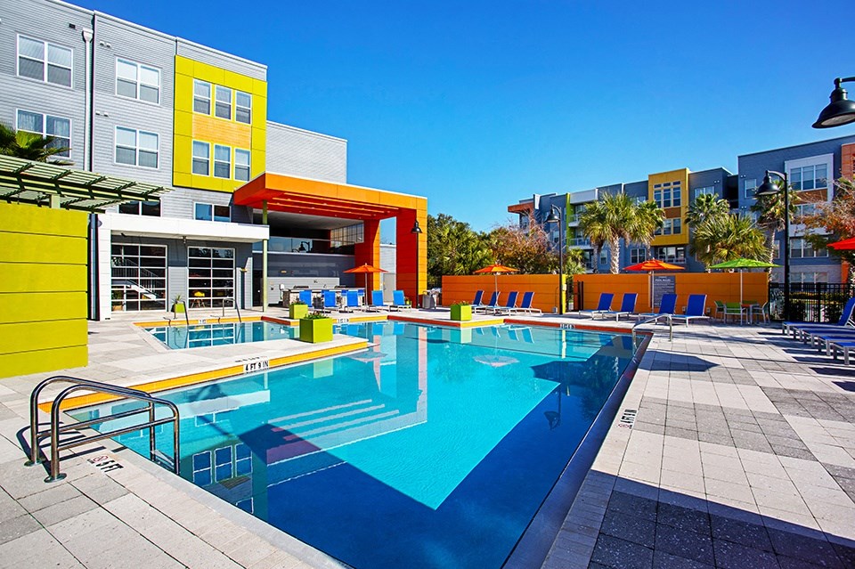 A swimming pool in a sunny outdoor pool area.