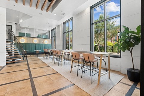 a dining room with tables and chairs and large windows