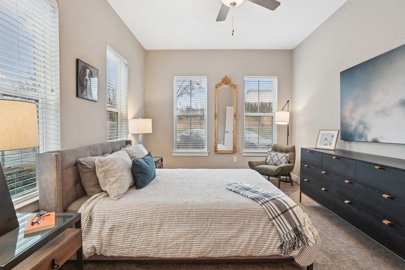 a bedroom with a large bed and a ceiling fan
