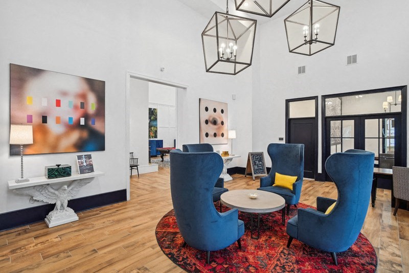 a living room with blue chairs and a round table