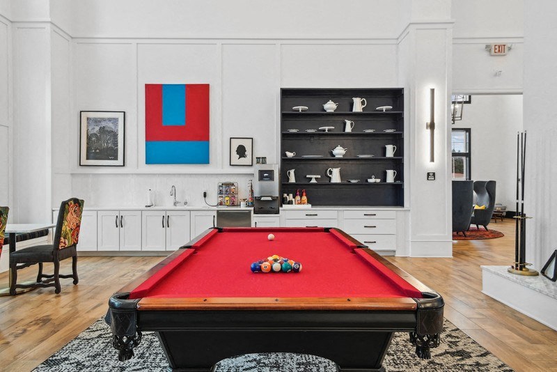 a red pool table in a living room with white walls