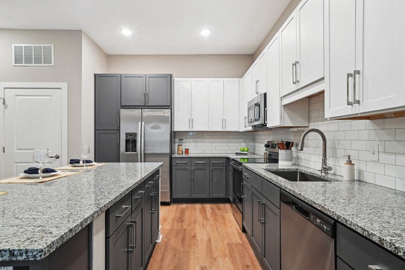 a modern kitchen with granite counter tops and black appliances