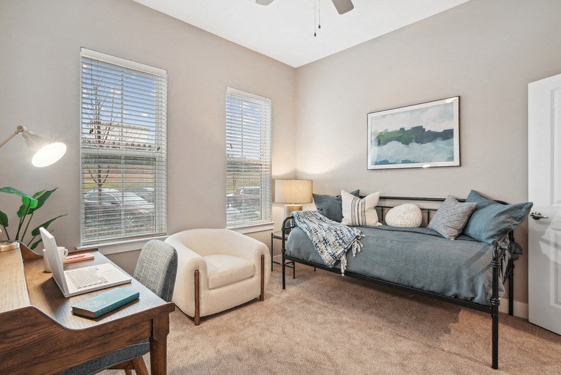 a bedroom with a bed and a desk with a laptop