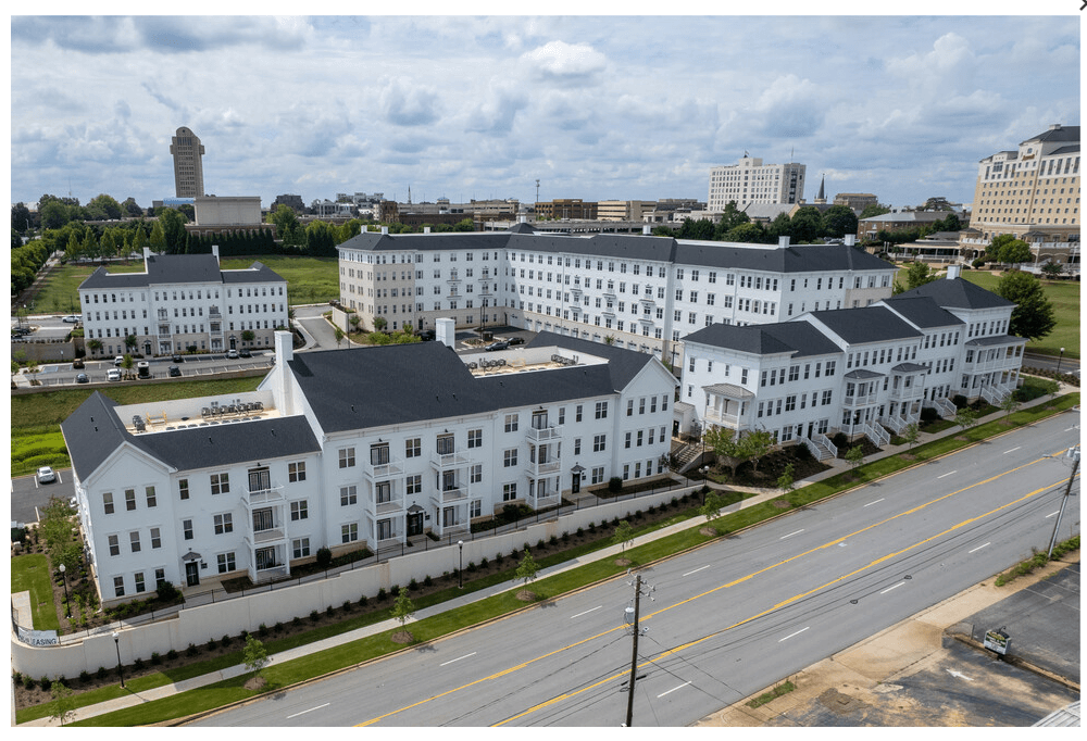 a view from the air of a large white building with many windows and a street in front