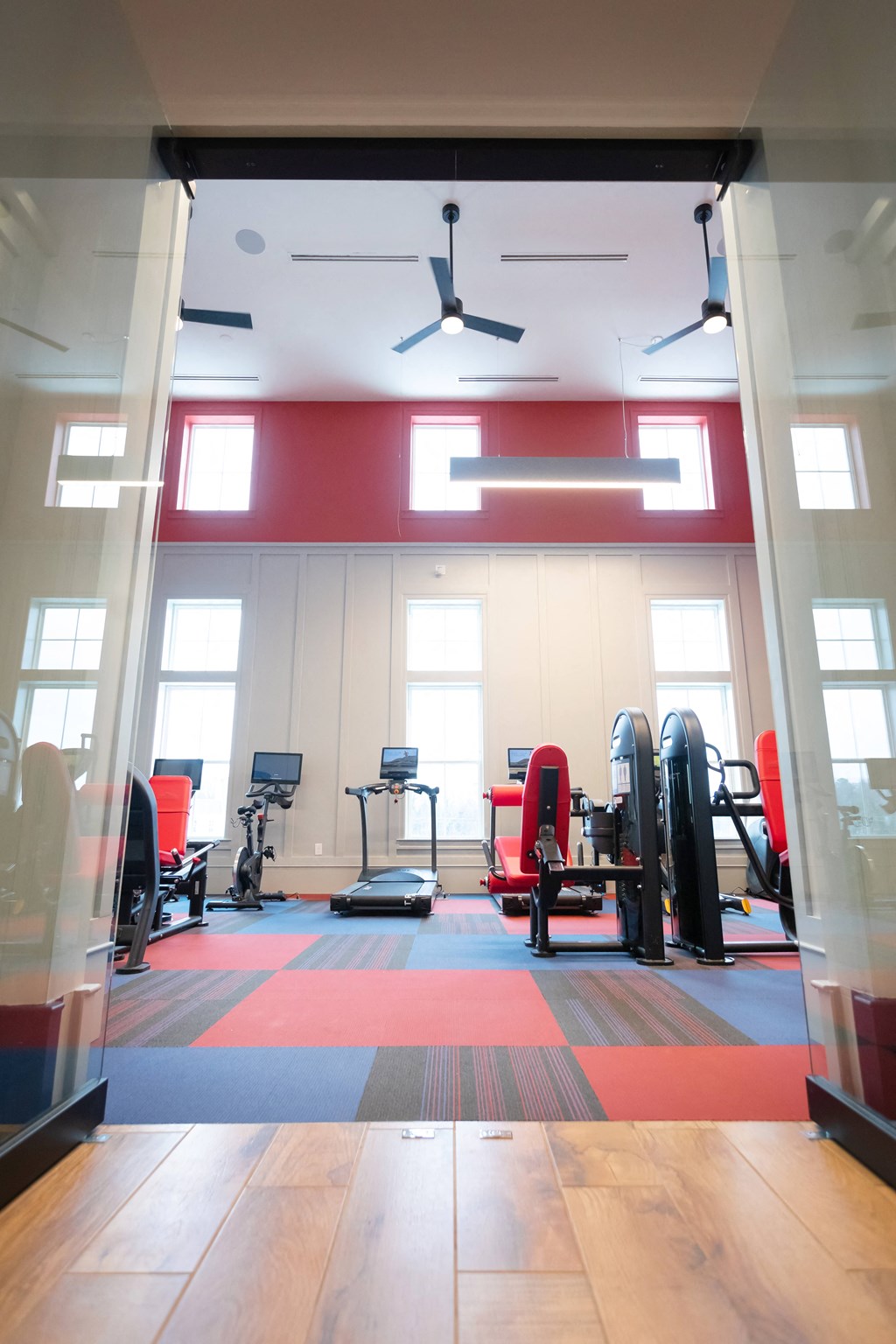 a gym with a red floor and red and black chairs