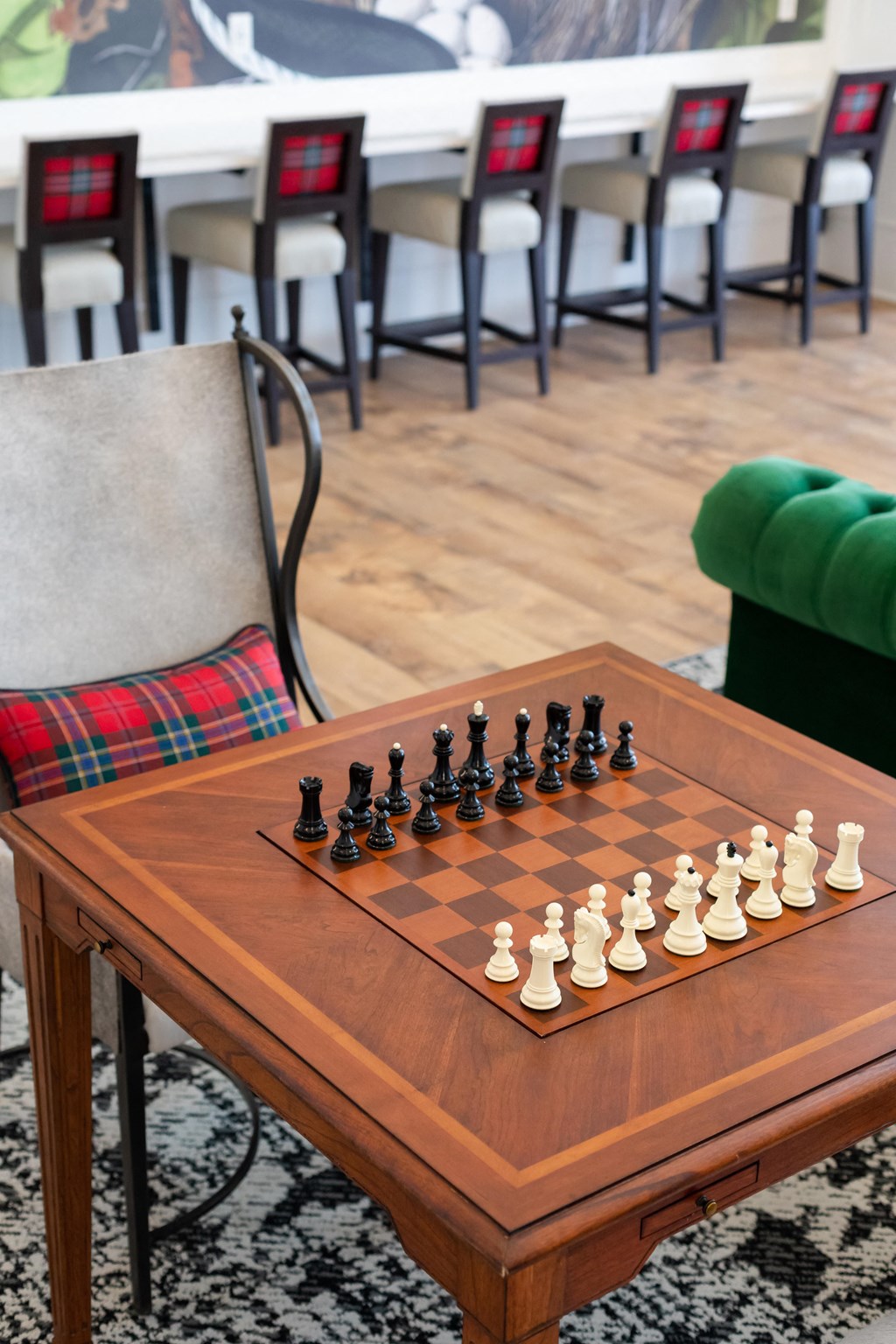 a chess board sits on a coffee table in front of a green chair