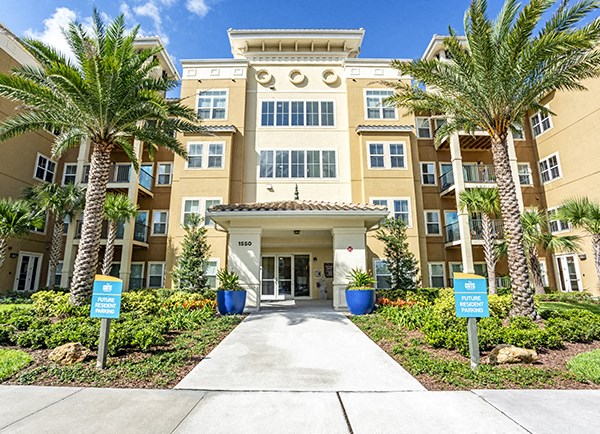 Exterior of clubhouse showing the entry and palm trees