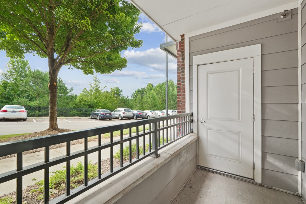 A white door is on the right side of a balcony.