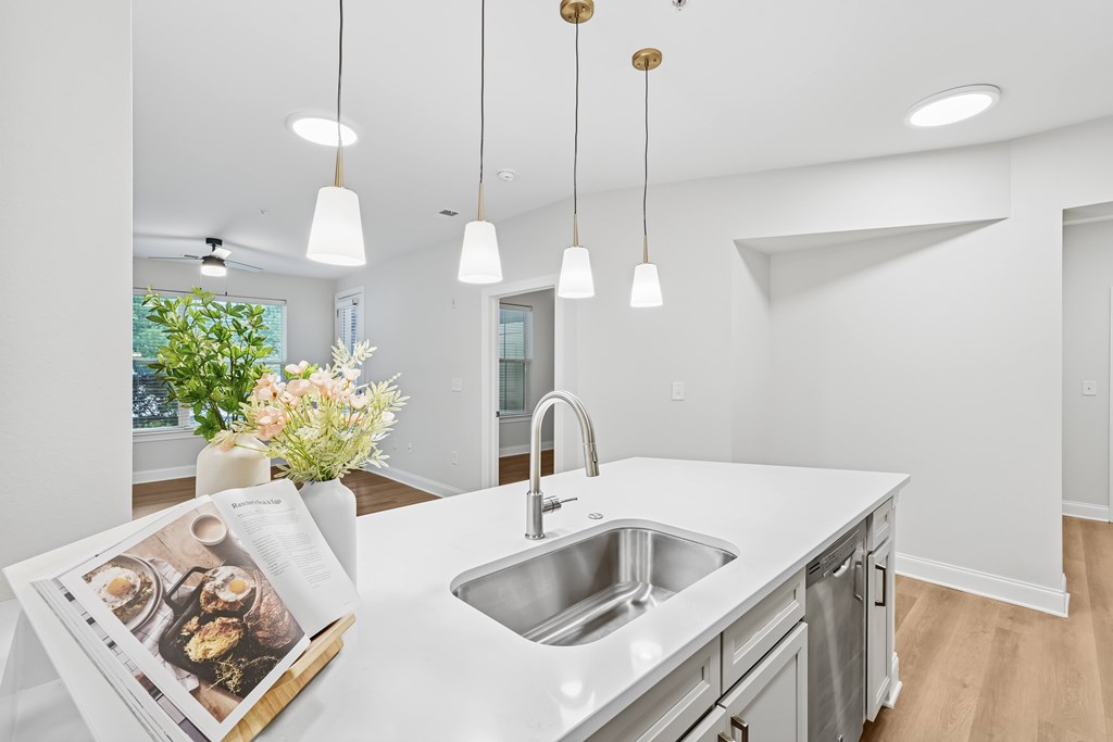 A kitchen with a white countertop and a sink.