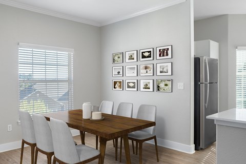 a dining room with a table and chairs and a refrigerator