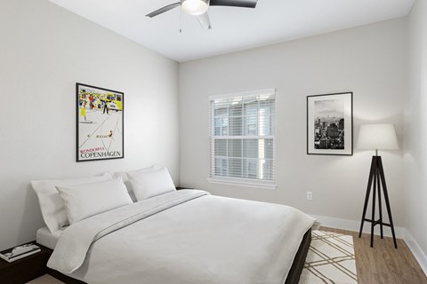 a white bedroom with a large bed and a ceiling fan