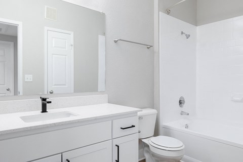 a white bathroom with a white sink and toilet and a tub