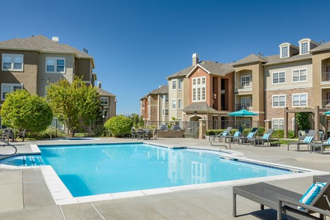 a swimming pool with an apartment building in the background