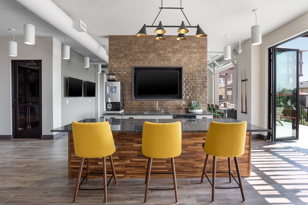 a living room with yellow chairs and a television