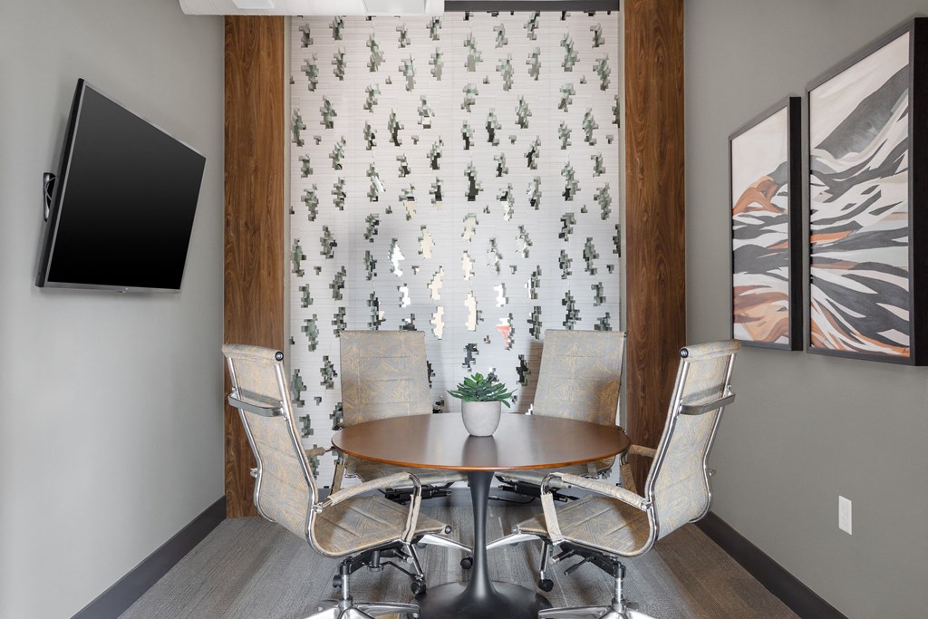 a conference room with a table and chairs and a television