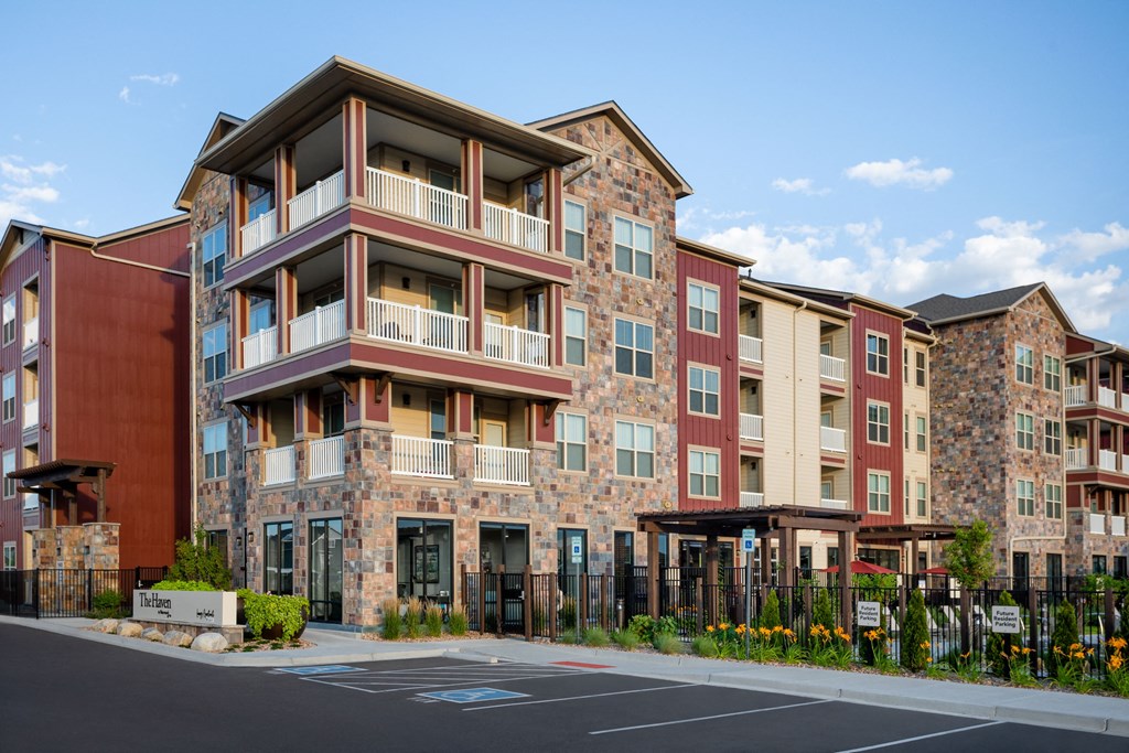 an exterior view of an apartment building with a parking lot
