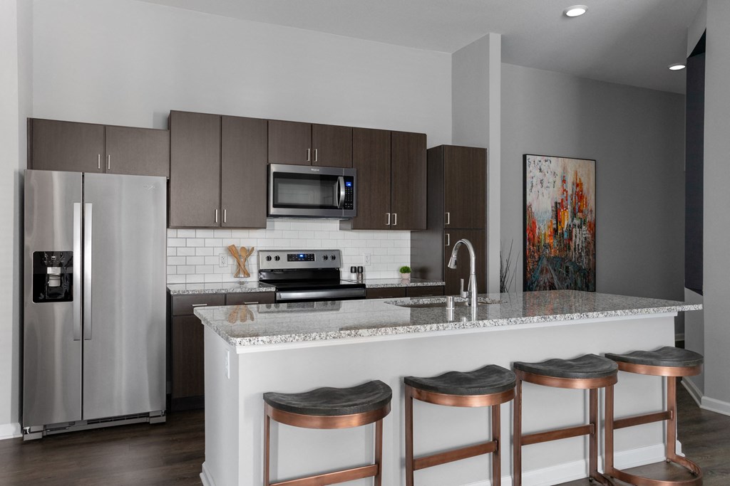 a kitchen with a marble counter top with four stools