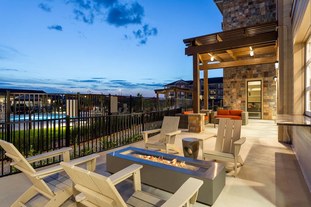 a covered patio with chairs and a fire pit