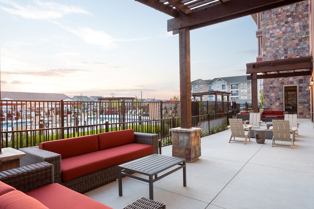 a patio with couches and tables and a pool in a building