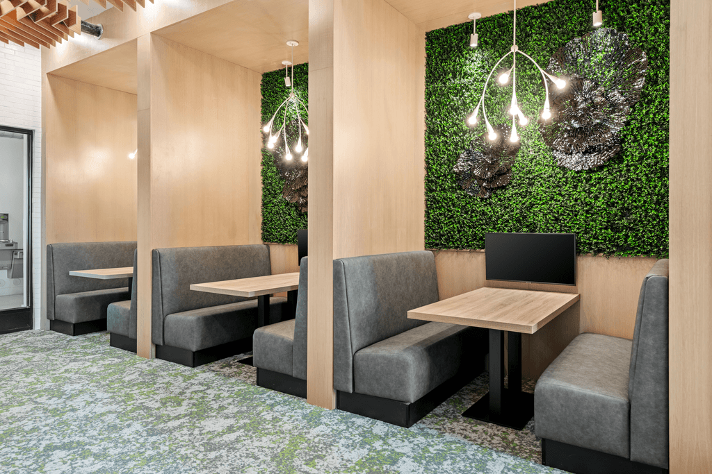 A room with a green wall and grey chairs.