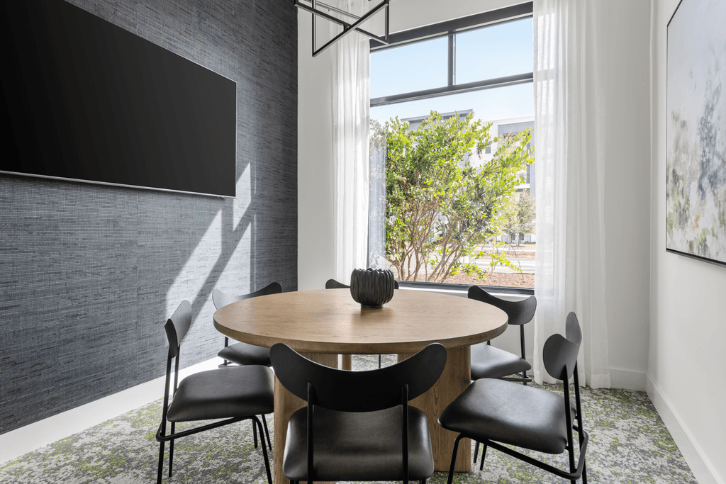 A modern dining room with a round table and chairs.
