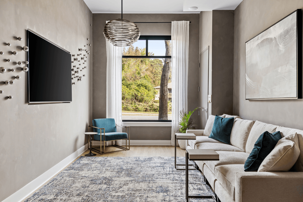 A living room with a couch, chair, and a television.