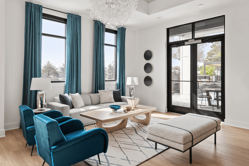 A living room with a blue chair and a white couch.