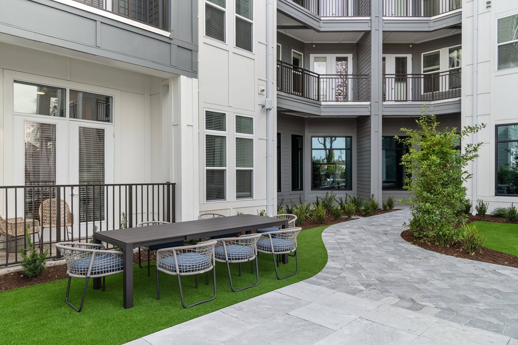 A patio with a table and chairs is in front of a building.