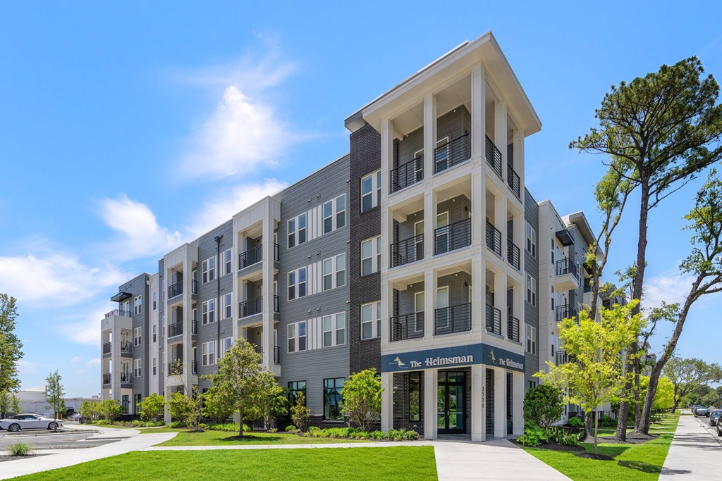 The Helmerman building is a modern apartment complex with multiple balconies and a green lawn in front.