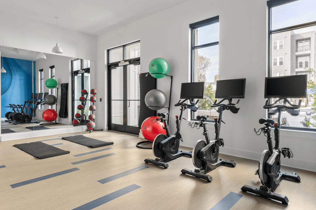A gym with exercise equipment and a view of a city.