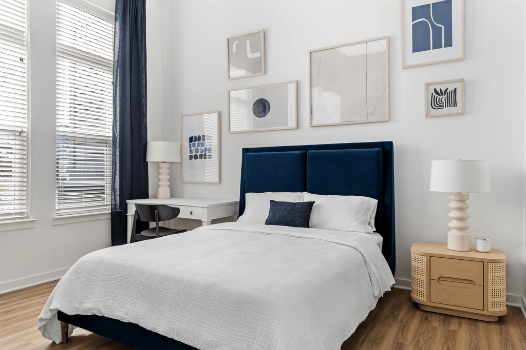 A bedroom with a large bed and a wooden nightstand.