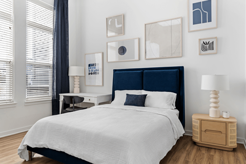 A bedroom with a large bed and a wooden nightstand.