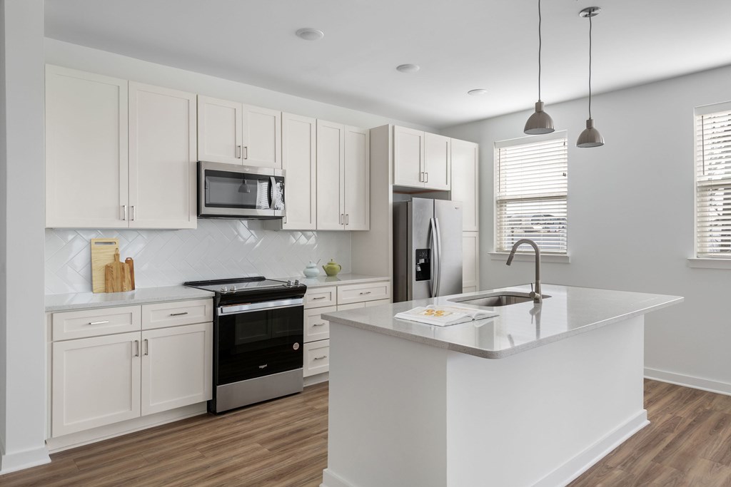 A modern kitchen with white cabinets and a large island.