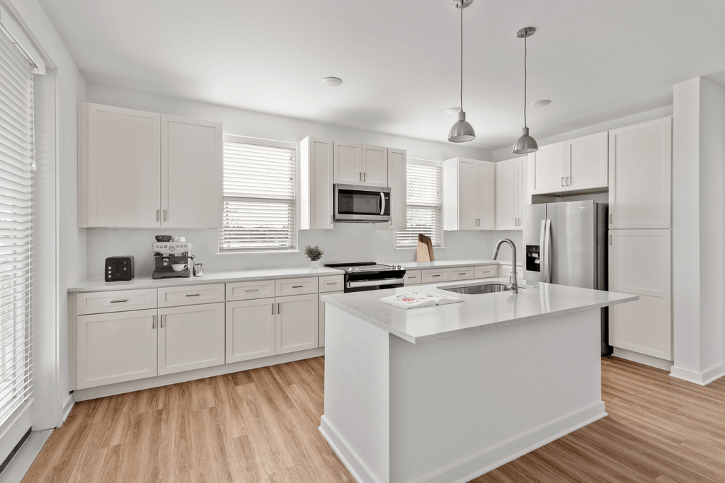 A modern kitchen with white cabinets and a central island.