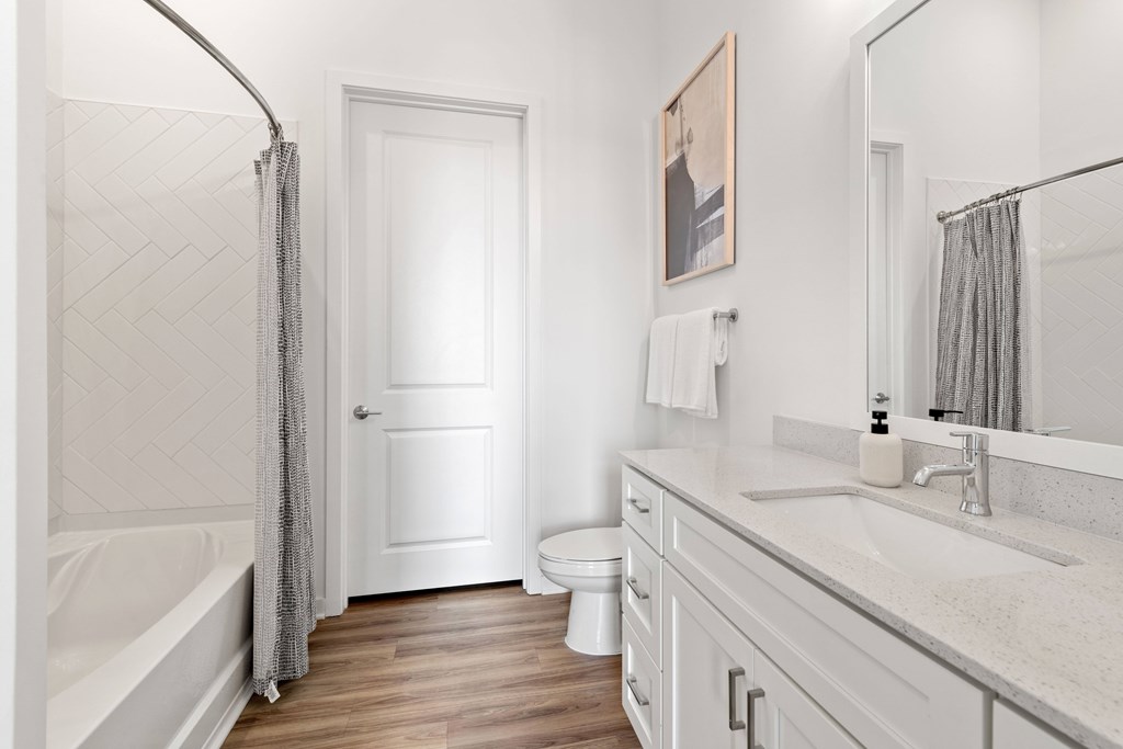 A white bathroom with a white door and a white toilet.