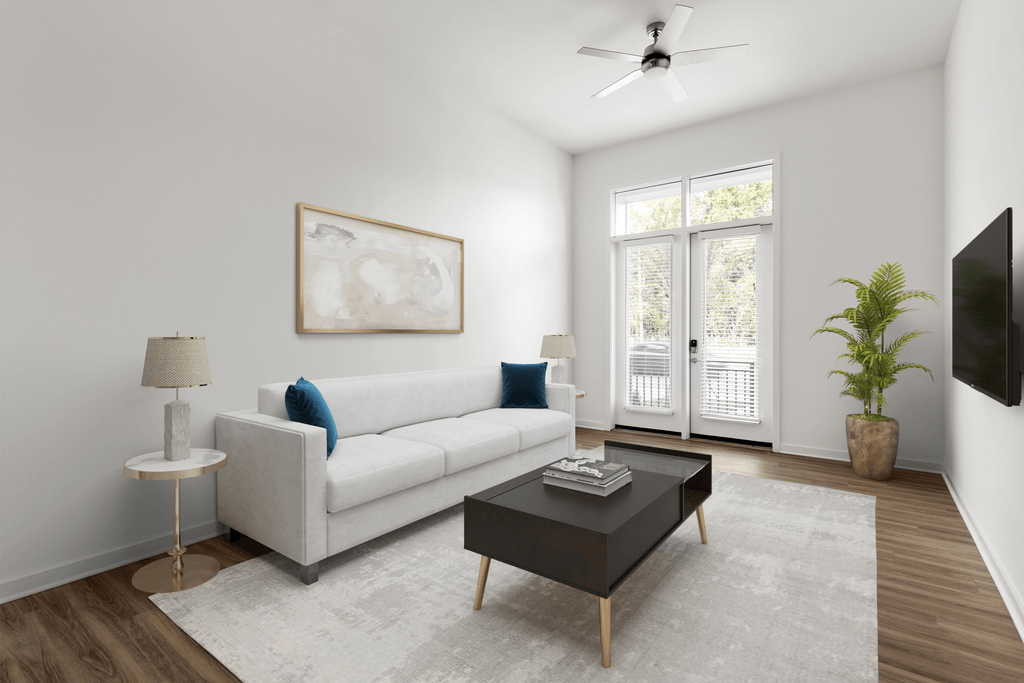 A living room with a white couch, a coffee table, a floor lamp, and a painting on the wall.