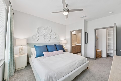 A bedroom with a large bed and a ceiling fan.