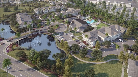 A bird's eye view of a residential area with a pond and palm trees.