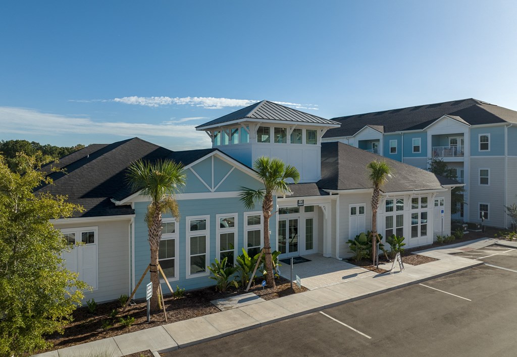 a home with a blue exterior and palm trees in front of it