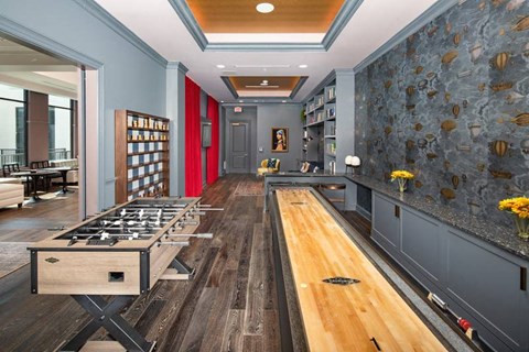 A game room with fooseball and shuffleboard
