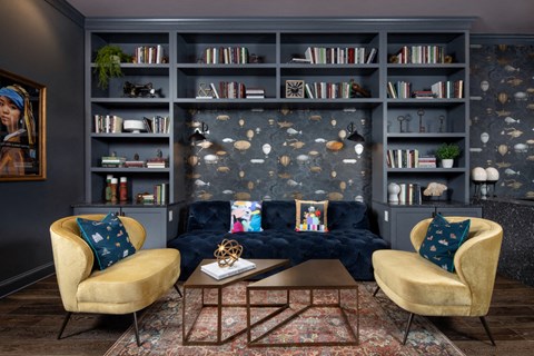 A lounge with a couch and two chairs that are facing each other