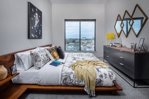 Bedroom with a bed in the foreground and a window on the back wall