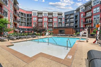 A large outdoor swimming pool surrounded by apartment buildings.