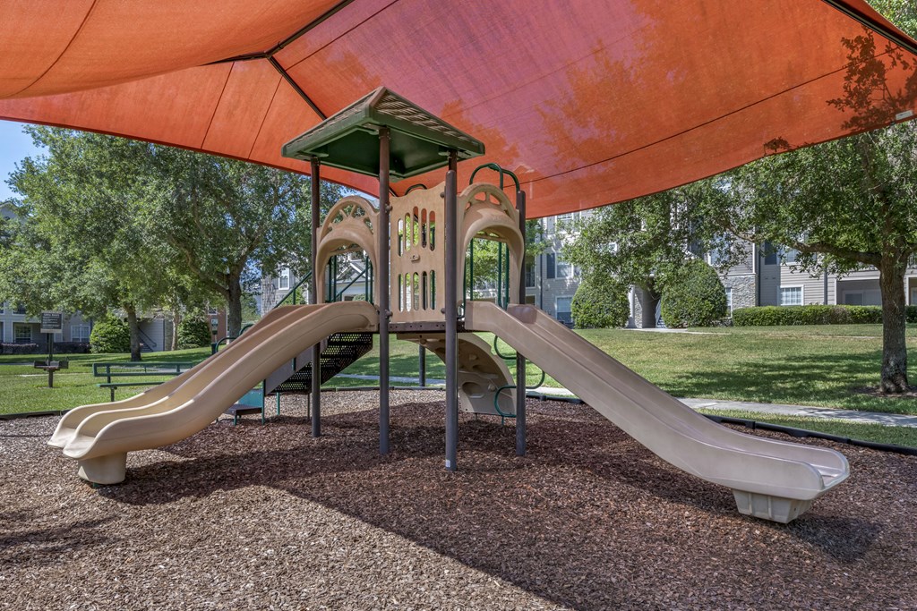 exterior playground with two slides and a climbing structure