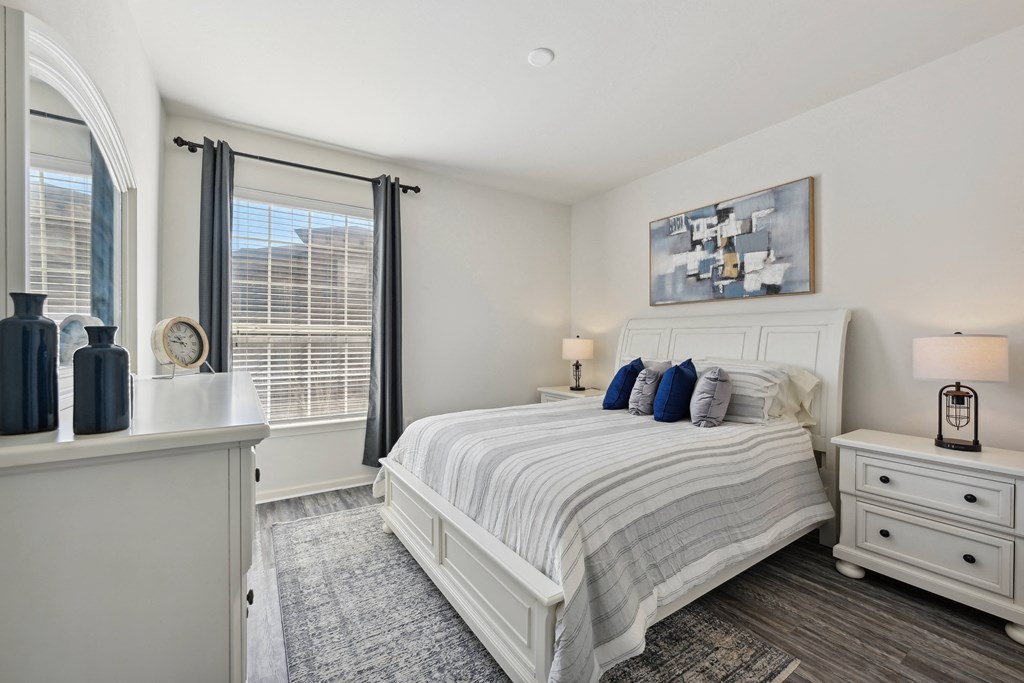 a white bedroom with a bed and a window