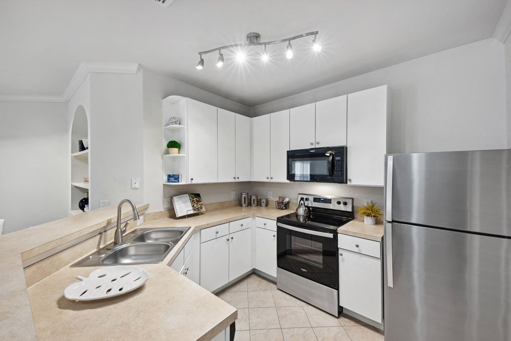a modern kitchen with stainless steel appliances and white cabinets
